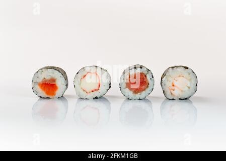Vier sushis auf weißem Hintergrund Ebi Maki, Kani Maki Sake Maki Maguro Maki. Stockfoto