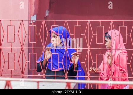 BAGERHAT, BANGLADESCH - 16. NOVEMBER 2016: Zwei Frauen hinter einem Zaun des Grabes von Khan Jahan Ali in Bagerhat, Bangladesch Stockfoto