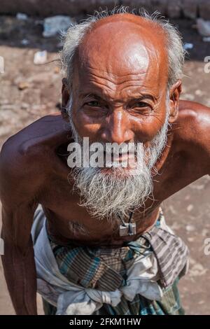 BAGERHAT, BANGLADESCH - 18. NOVEMBER 2016: Alter Mann auf einem Busstand in Bagerhat, Bangladesch Stockfoto