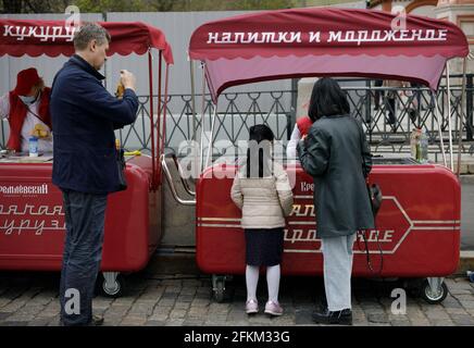02. Mai 2021, Moskau, Roter Platz. Familie auf einem Spaziergang in Die Stadt kauft einem Kind von einem Eis Mobiles Tablett Stockfoto