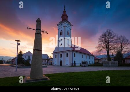 Kirche und Schlagpfosten auf dem Hauptplatz von Sucany, Slowakei. Stockfoto