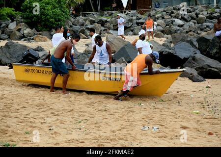 salvador, bahia, brasilien - 2. februar 2021: In der Stadt Salvador werden Fischer gesehen, wie sie ein kleines fibria-Boot auf dem Strandsand schieben. Stockfoto