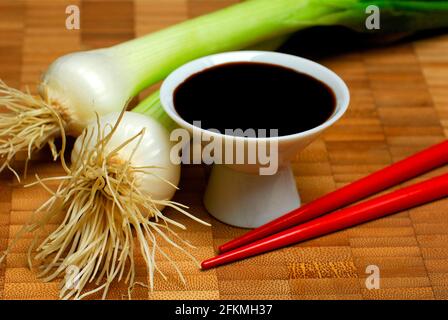 Sojasauce in einer Schüssel, Essstäbchen und Frühlingszwiebeln, Sojasauce Stockfoto