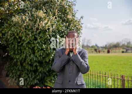 Besorgter Geschäftsmann berührt sein Gesicht mit seinen Händen Stockfoto