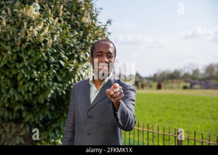 Erfolgreicher afrikanischer Geschäftsmann, der mit dem Finger auf die Kamera zeigt Wie wir Sie wollen Stockfoto