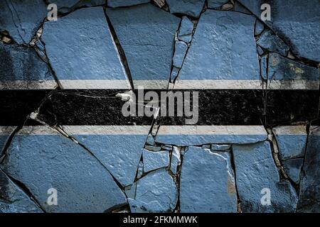 Nationalflagge von Botswana, die in Farbfarben auf einer alten Steinmauer abgebildet ist. Flaggenbanner auf gebrochenem Wandhintergrund. Stockfoto