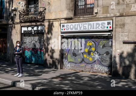 Barcelona, Spanien. Mai 2021. Eine junge Frau wartet auf einen Stadtbus auf der Rambla vor einem Souvenirladen, der für die Öffentlichkeit gesperrt ist. Es bleibt noch eine Woche, bis der von der spanischen Regierung verordnete Alarmzustand aufgrund von Covid-Infektionen beendet ist, aber Barcelona braucht dringend die massive Ankunft des Tourismus, der die Stadt besucht, um ihre Wirtschaft und ihren Handel zu reaktivieren. (Foto von Paco Freire/SOPA Images/Sipa USA) Quelle: SIPA USA/Alamy Live News Stockfoto