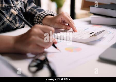 Frau Buchhalterin, die mit Computer und Rechner für geschäftliche und finanzielle Ausgaben arbeitet. Stockfoto