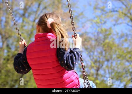 Mädchen schwingt auf einem Spielplatz (Model veröffentlicht) Stockfoto