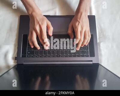 Männliche Hände tippen auf Laptop-Tastatur, Arbeitskonzept Stockfoto