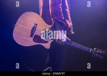 Ein Mann, der eine akustische Gitarre in den Händen hält. Stockfoto