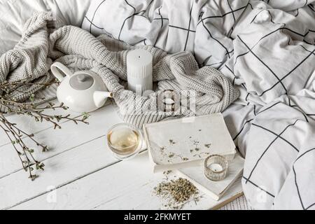 Gemütliches Zuhause Komposition mit einer Tasse Kräutertee und Bücher auf einer Holzoberfläche. Stockfoto