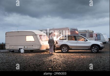 Garrettstown, Cork, Irland. Mai 2021. Die Urlauber Viaslav Koski und Boglava Szyczak haben sich mit ihrem Wohnwagen vor Sonnenaufgang entschlossen, die Insel zu verlassen und sich in Garrettstown, Co. Cork, Irland, auf eine Niederdruckwetterfront mit starken Winden und sintflutartigen Regenfällen zu begeben. - Credit; David Creedon / Alamy Live News Stockfoto