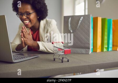 Glückliche afroamerikanische Frau, die online über Laptop kauft, freut sich über den Verkauf Angebot Stockfoto
