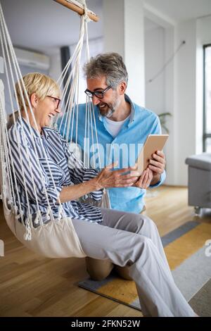Glücklich lächelnd reifes Paar mit digitalen Tablet zu Hause Stockfoto