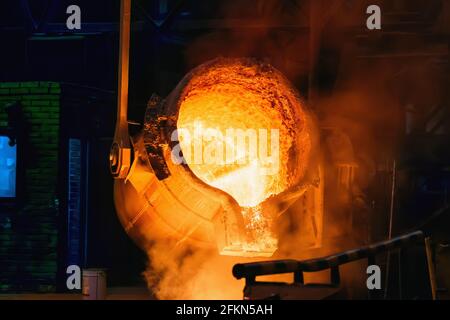 Metallgussverfahren in der Gießerei wird geschmolzenes Eisen aus der Gießpfanne in den Hochofen gegossen. Stockfoto