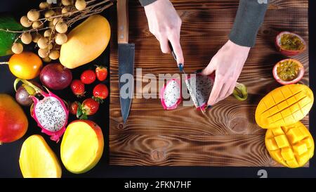 Foto von Frau schneidet Drachenfrucht, Draufsicht Stockfoto