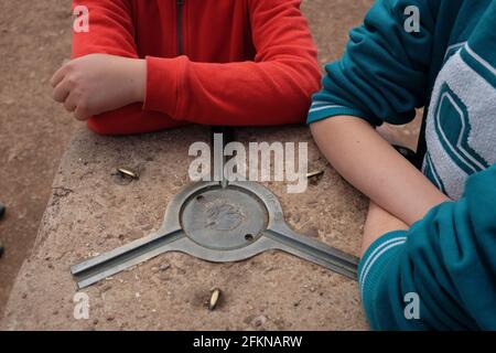 Zwei Kinder, die ihre Arme auf einem Trig-Punkt ruhen. Walton Hill, Clent, Worcestershire Stockfoto