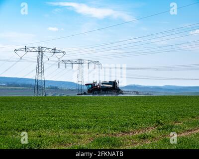 Traktor sprüht Pestizide auf einem Feld Stockfoto