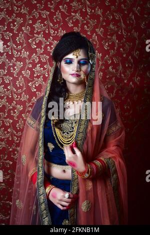Vertikale Aufnahme einer hübschen und attraktiven indischen Frau, die posiert Mit traditioneller Brautkleidung Stockfoto