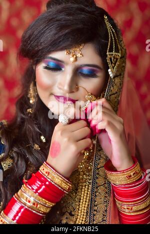 Hübsche und attraktive indische Frau mit traditioneller Brautkleiderbefestigung Ihre Nase piercing Stockfoto