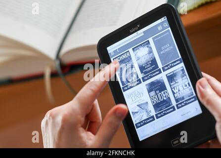 Berlin, Deutschland. April 2021. ILLUSTRATION - EINE Frau hält einen eBook Reader in den Händen und schaut sich die Auswahl aktueller Bücher an. Quelle: Jens Kalaene/dpa-Zentralbild/ZB/dpa/Alamy Live News Stockfoto