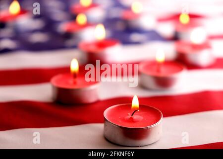 Trauerkerzen brennen auf US-amerikanischer Nationalflagge Hintergrund. Memorial Weekend, Patriot Veterans Day, 9/11 National Day of Service & Remembrance. Stockfoto