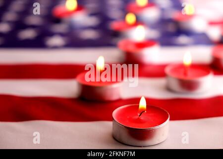 Trauerkerzen brennen auf US-amerikanischer Nationalflagge Hintergrund. Memorial Weekend, Patriot Veterans Day, 9/11 National Day of Service & Remembrance. Stockfoto