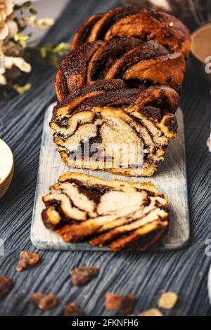 Traditioneller polnischer Babka-Kuchen mit Schokolade auf Holzschneidebrett Stockfoto