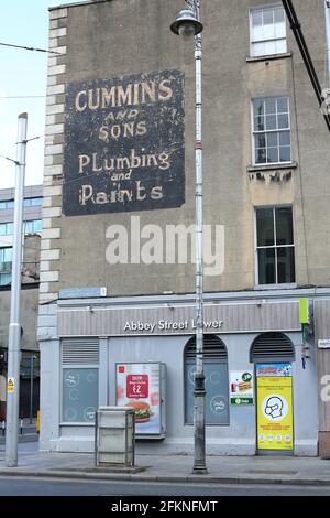 Altes bemaltes Schild an der Straße in Dublin für Cummins und Sons Sanitär und Farben Stockfoto