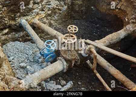 Alte Stadt Wasser Haupthähne, ein Loch gegraben, um zu reparieren oder ersetzen Wasserversorgungseinheiten Stockfoto