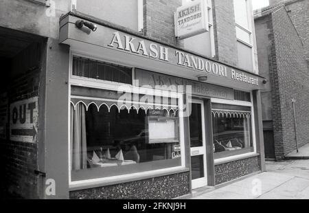 1980er, Außenansicht eines indischen Restaurants, dem Akash Tandoori, York, England, Großbritannien. Tandoori ist eine indische Kochweise, die auf der Verwendung eines Tandoors basiert, einem zylindrischen Tonofen, der aus Südasien, insbesondere Nordindien, stammt. Seit die indische Küche in Großbritannien eingeführt wurde, ist sie sehr beliebt geworden. Stockfoto