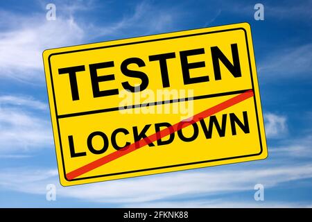 Ortsschild gelb auf Himmel Lockdown kontra Tests Stockfoto