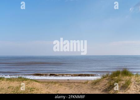 Wellen brechen auf Buche Mablethorpe Lincolnshire Stockfoto