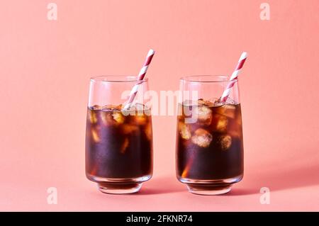 Iced Cola oder Cold Coffee in hohen Gläsern auf rosa Hintergrund. Konzept Erfrischendes Sommergetränk. Stockfoto