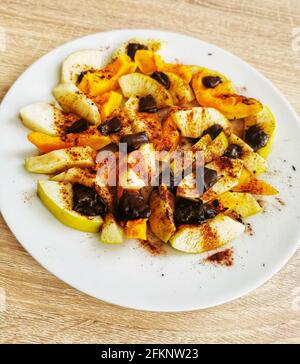 Gebackene Apfel- und Kürbisstücke mit Zimt und Schokolade Stockfoto