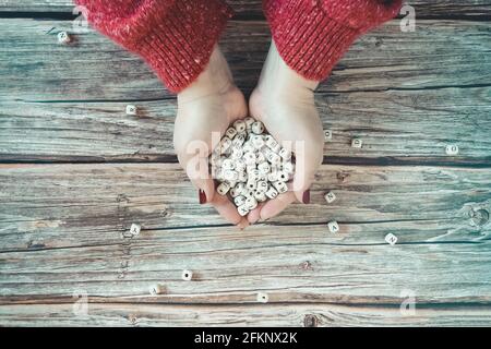 Die Hände der Frauen halten Holzwürfel mit den Buchstaben des Alphabets. Speicherplatz kopieren. Stockfoto
