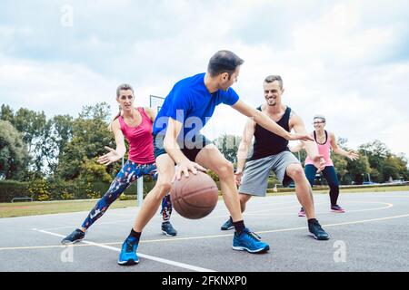 Basketballspieler, die auf dem Platz im Freien spielen Stockfoto