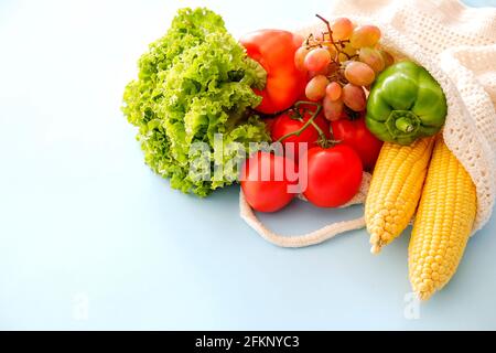 Gemischte Bio-Früchte, Gemüse & Gemüse: Maiskolben, Tomaten, Pfeffer, Salatsalat, Trauben und Äpfel in wiederverwendbarem Baumwollnetzbeutel. Keine Wa Stockfoto