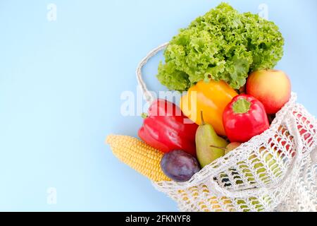 Gemischte Bio-Früchte, Gemüse und Gemüse: Maiskolben, Tomaten, Pfeffer, Salatsalat, Birne, Pflaumen und Äpfel in wiederverwendbarem Baumwollnetzbeutel. Zer Stockfoto