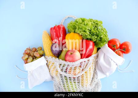 Gemischte Bio-Früchte, Gemüse und Gemüse: Maiskolben, Tomaten, Pfeffer, Salatsalat, Birne, Pflaumen und Äpfel in wiederverwendbarem Baumwollnetzbeutel. Zer Stockfoto