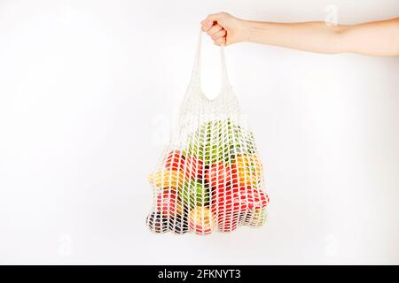 Unkenntlich, die Hand einer Frau, die eine Tüte mit gemischtem Obst, Gemüse und Gemüse hält: Maiskolben, Tomaten, Pfeffer, Salat, Birne und Apfel. Null-Abfall-Koncep Stockfoto