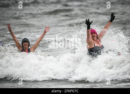 Montag, 3. Mai 2021. Langland Bay, Swansea, Wales. Schwimmer in Langland Bay, Swansea, als sie an einem nassen und windigen Montag an den Bankfeiertagen dem kühlen Meer trotzen, da schlechtes Wetter den Großteil Großbritanniens beeinflusst. Stockfoto