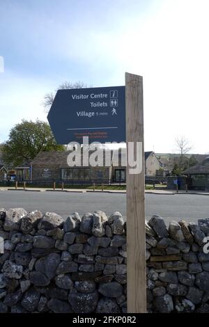 Hölzerner Wegweiser zum Village Center im Grassington Car Park auf dem Dales Way Long Distance Path im Yorkshire Dales National Park, England, Großbritannien. Stockfoto