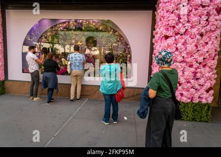 New York, USA. Mai 2021. Besucher vor Macy's Flagship-Kaufhaus am Herald Square in New York, das mit Blumenarrangements für die jährliche Macy's Flower Show am Eröffnungstag Sonntag, den 2. April 2021, behauen ist. Besucher strömen zur diesjährigen Show mit dem diesjährigen Thema, geben. Liebe. Bloom.“ Die Show, die letztes Jahr aufgrund der Pandemie auf Pause war, wurde entwickelt, um soziale Distanzierungen zu fördern. Die Show läuft bis zum 16. Mai. (Foto von Richard B. Levine) Quelle: SIPA USA/Alamy Live News Stockfoto