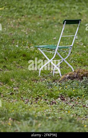 Grün und weiß bemalter Biergartenstuhl im Park Stockfoto