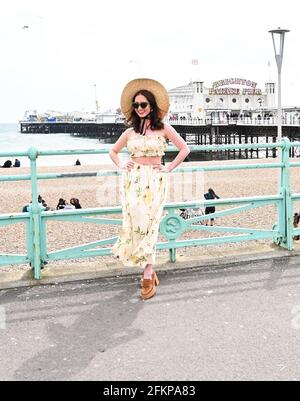 Brighton UK 3. Mai 2021 - EINE junge Dame posiert für Fotos an der Strandpromenade von Brighton, während Besucher trotz des windigen Wetters die Feiertage im Mai genießen : Credit Simon Dack / Alamy Live News Stockfoto