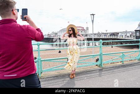 Brighton UK 3. Mai 2021 - EINE junge Dame posiert für Fotos an der Strandpromenade von Brighton, während Besucher trotz des windigen Wetters die Feiertage im Mai genießen : Credit Simon Dack / Alamy Live News Stockfoto