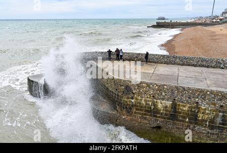 Brighton UK 3. Mai 2021 - Wellen stürzen an die Strandpromenade von Brighton, während Besucher trotz des windigen Wetters die Feiertage im Mai genießen : Credit Simon Dack / Alamy Live News Stockfoto