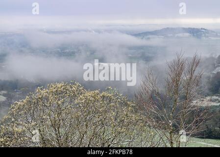 Birdlip, Cotwolds, Gloucestershire, Großbritannien mit Nebel und Schnee im April. Blick über das Avon Valley. Stockfoto